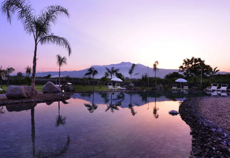 Lago-piscina del Santantonio Resort al tramonto con riflessi sull’acqua